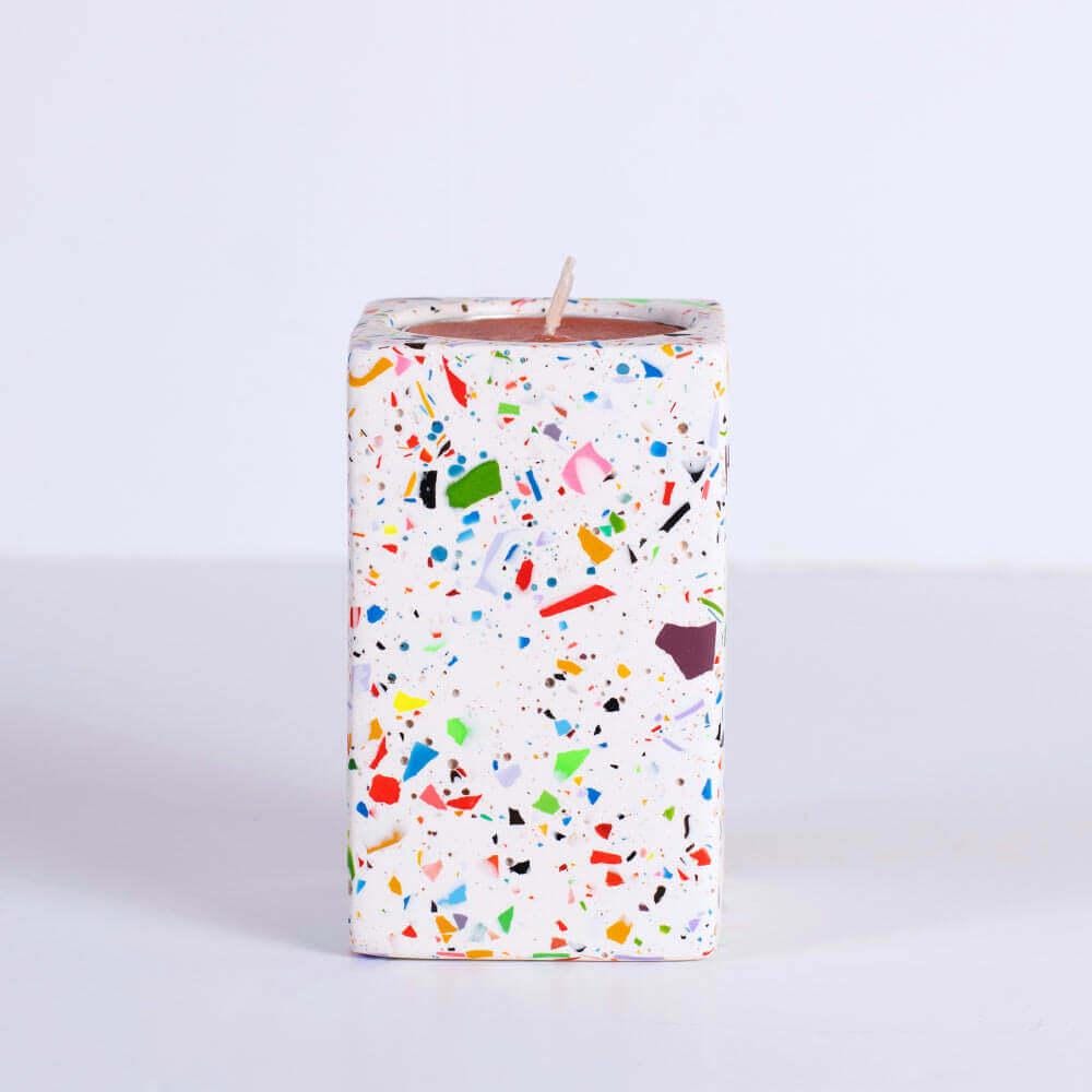 Candle with rainbow confetti rectangular tea light candle holder on a white background