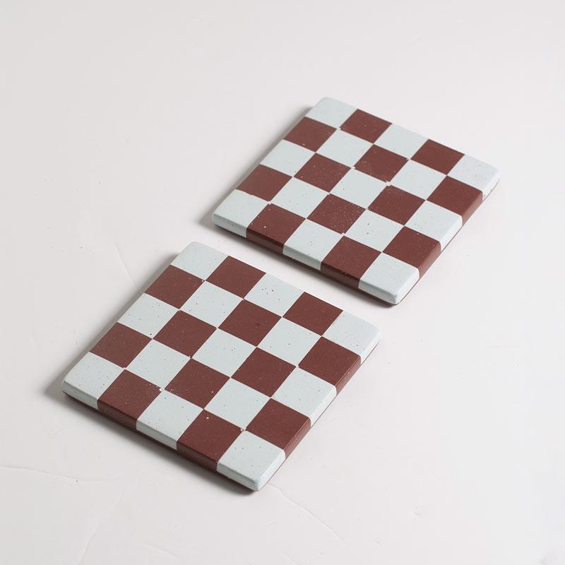 Two checkered coasters on a light grey background