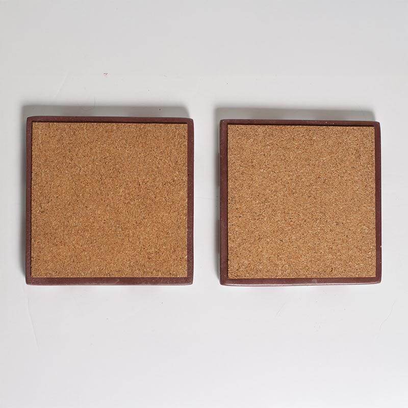 Two square cork coasters on a white background