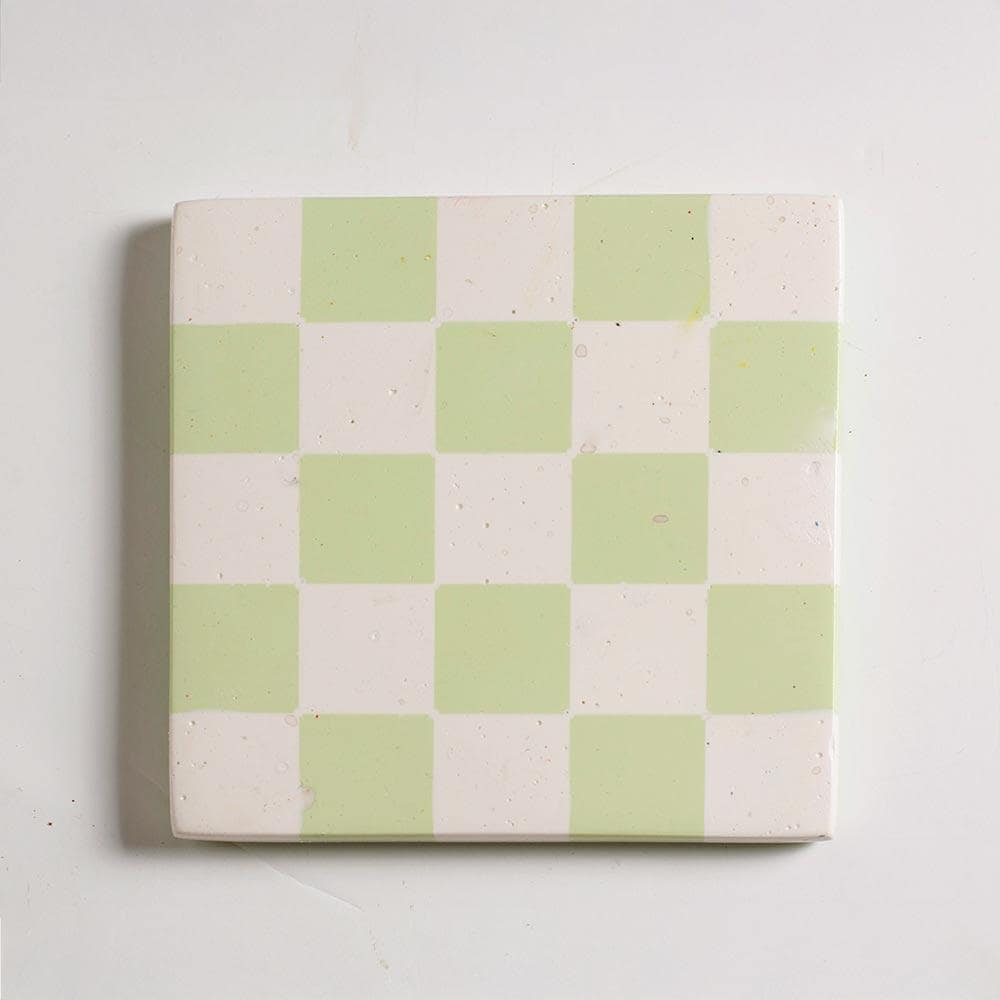 Mint green and white checkered coaster on a white background