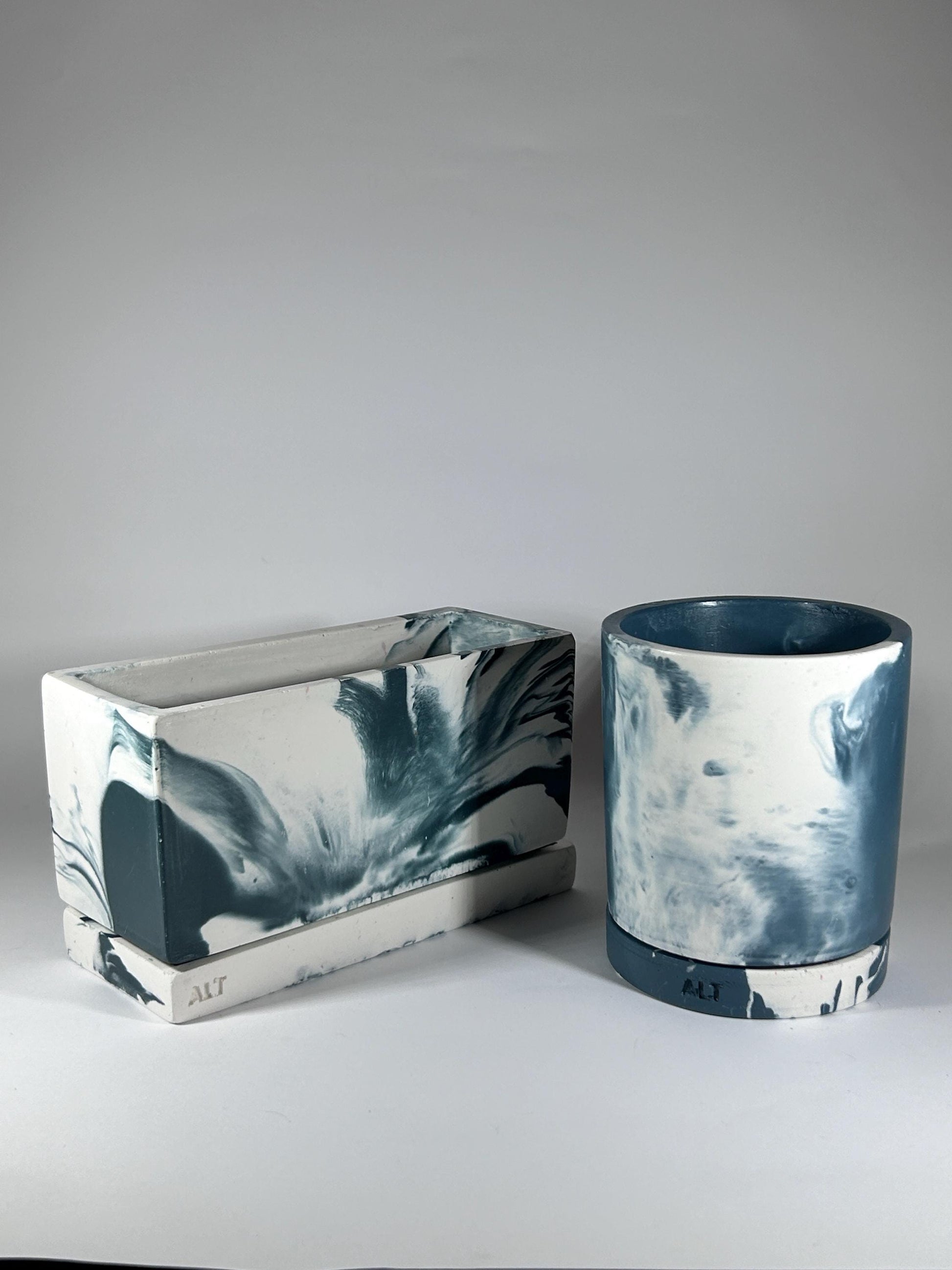Two plant pots with marbled blue and white design on a grey background