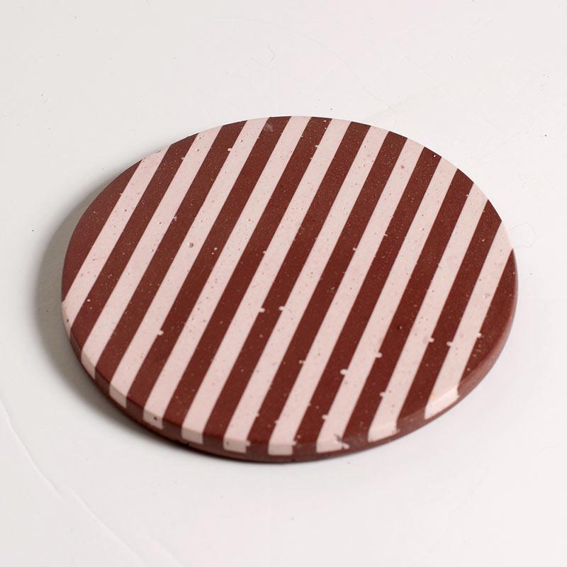 Burgundy and light pink checkered coaster on a white background