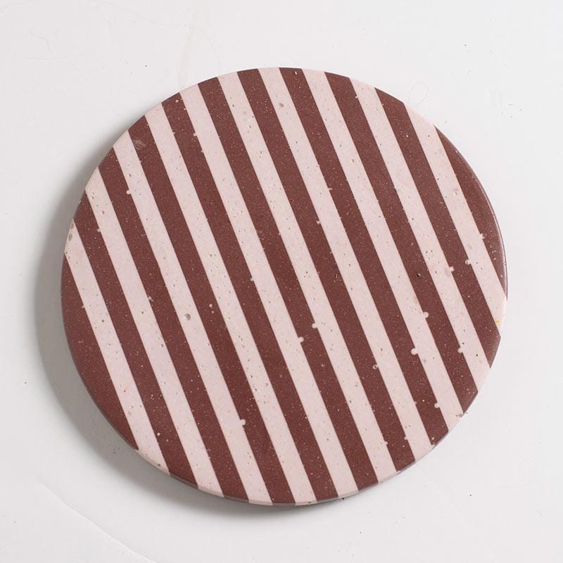 Burgundy and light pink checkered coaster on a white background
