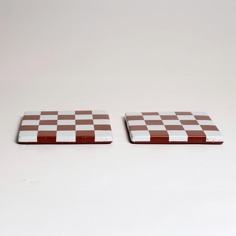 Two checkered coasters on a white background