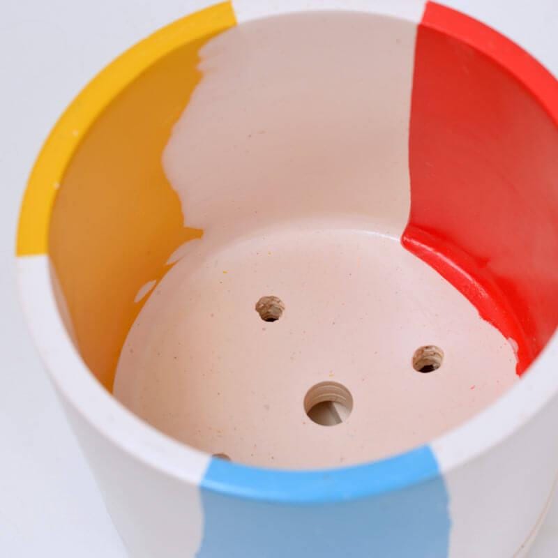Close up of the Chunky Cylindrical plant pot with blue, yellow and red stripes on a white background