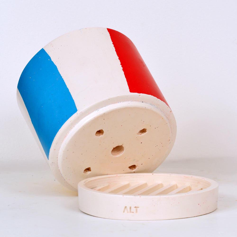 Chunky Cylindrical plant pot with blue, yellow and red stripes on a white background