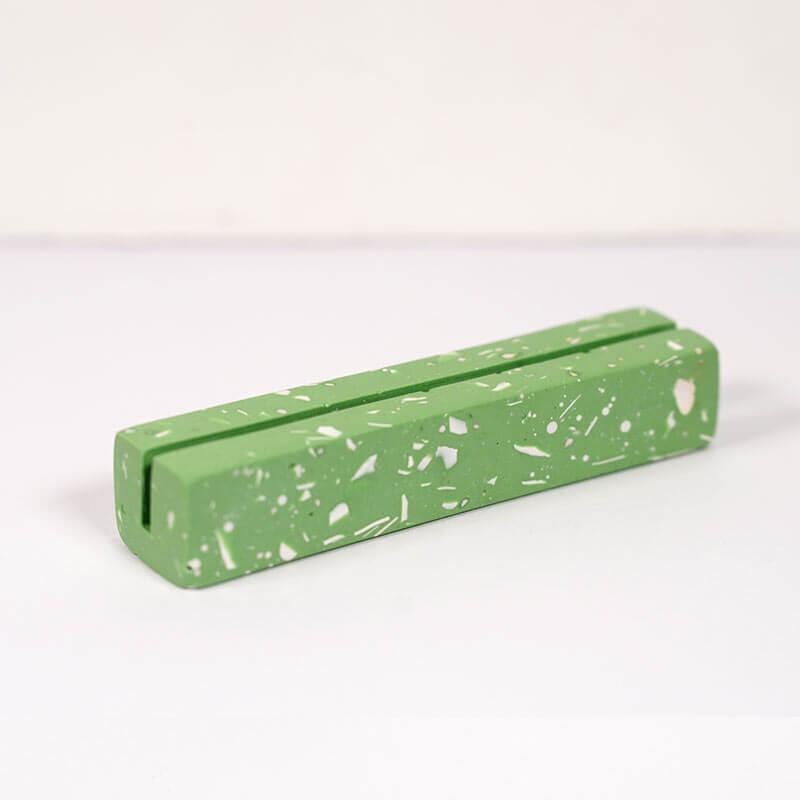 Green rectangular object with speckled pattern on a white background