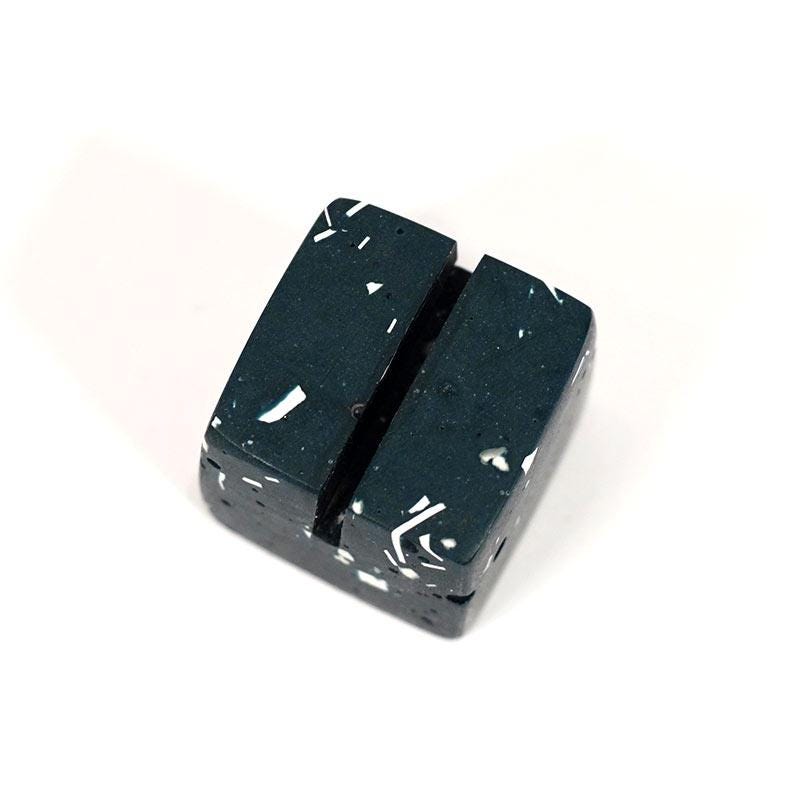 Two black rectangular blocks with white speckles on a white background