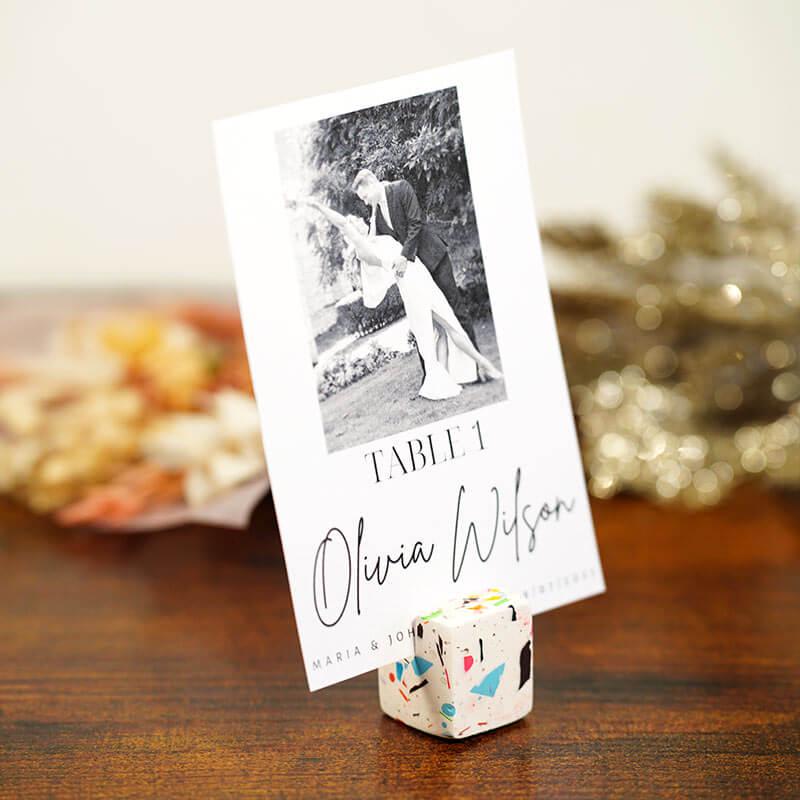 Wedding table name card with a black and white photo and name on a wooden surface