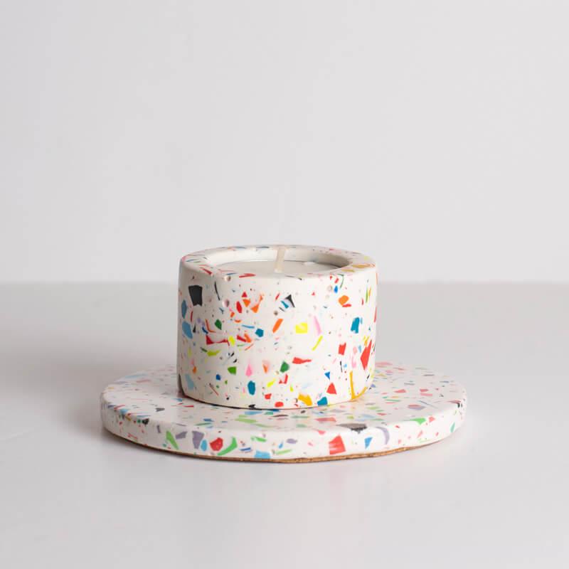 Rainbow terrazzo candle holder on a coaster on a white background
