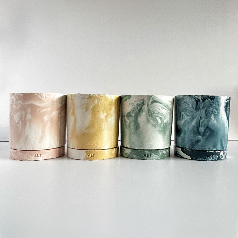 Four Marbled planters with a drainage hole and separate water trays with 'ALT' branding on a light gray background