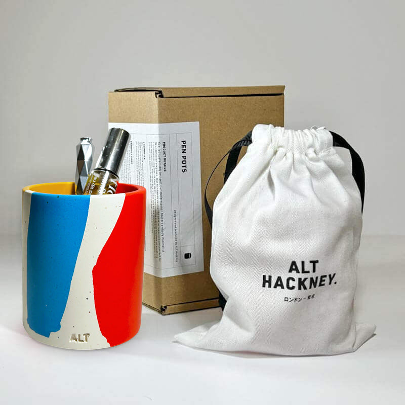 Colourful pen holder with a box and drawstring bag on a white backgroun
