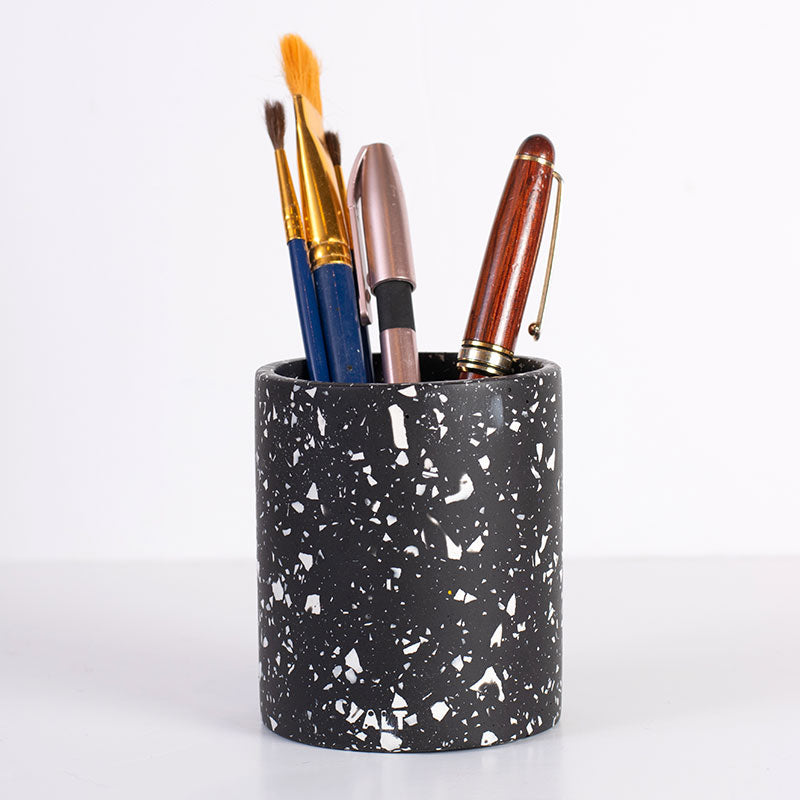 Black terrazzo pen holder with various brushes on a white background