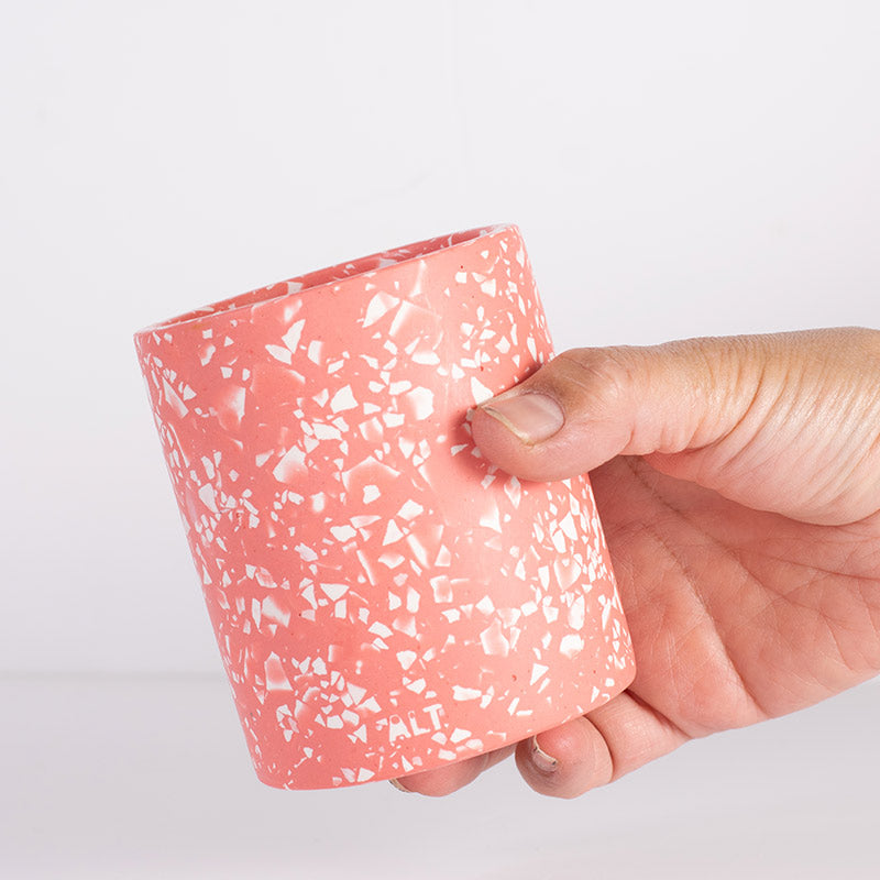Hand holding a Blue terrazzo pen pot on a light grey background