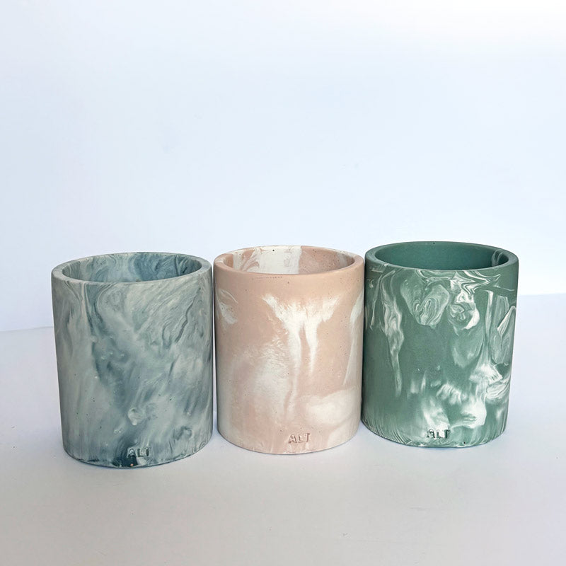 Three marble patterned pencil holders on a white background