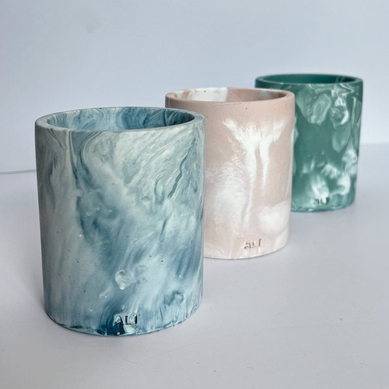 Three marble patterned pencil holders on a white background