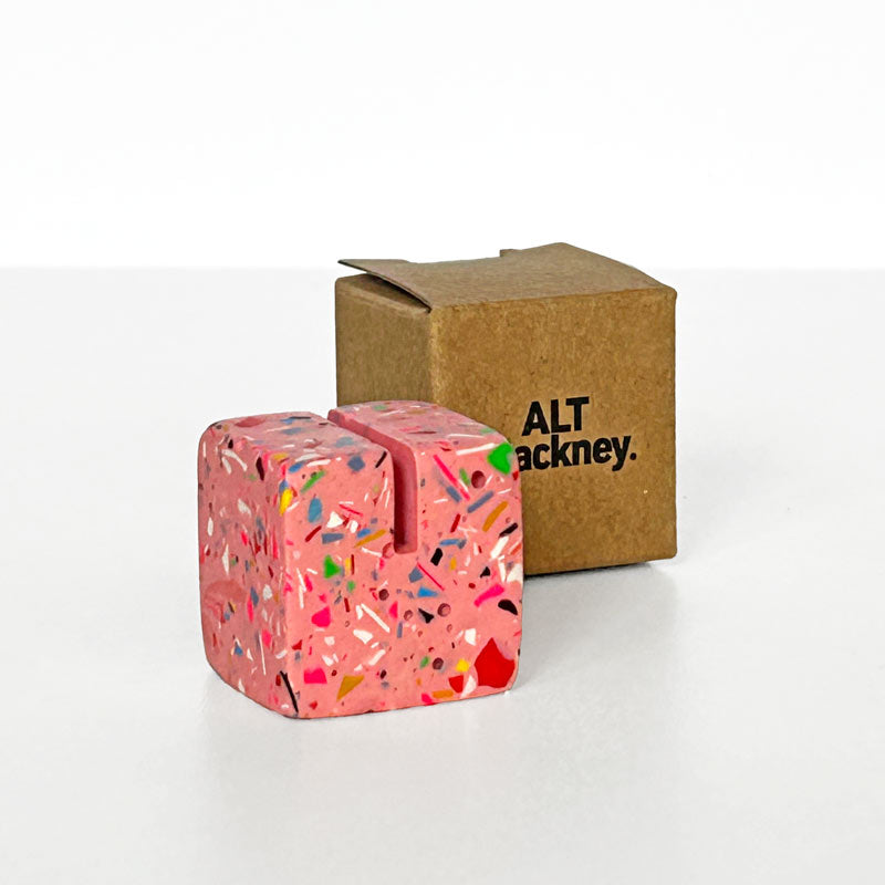 Pink Photo Holder with colourful rainbow terrazzo next to a brown box with 'ALT Hackney' branding