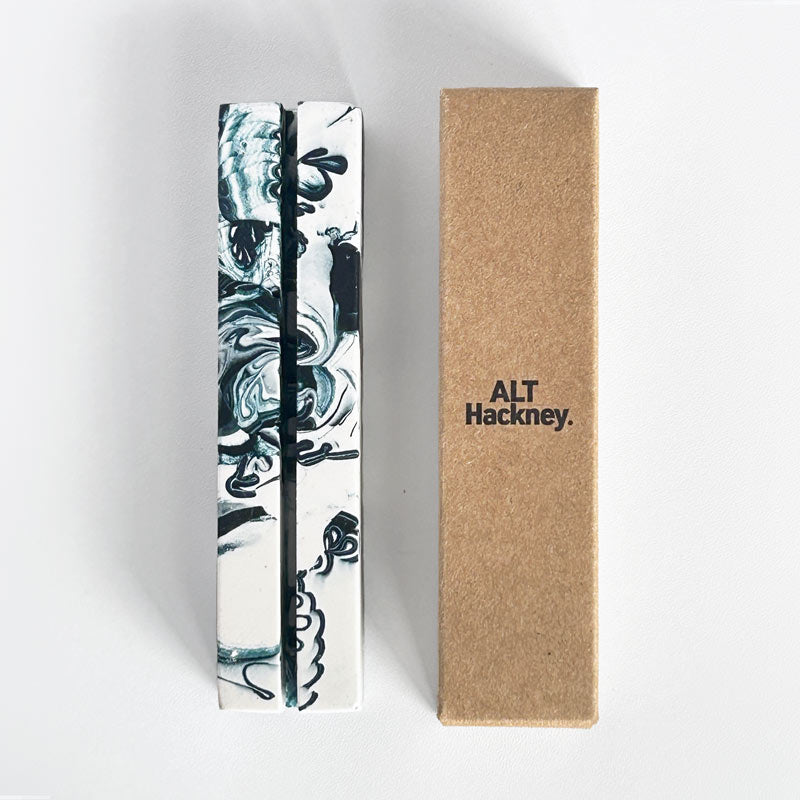 Marble-patterned navy rectangular photo holder and an eco brown box with 'ALT Hackney.' branding, on a white background.