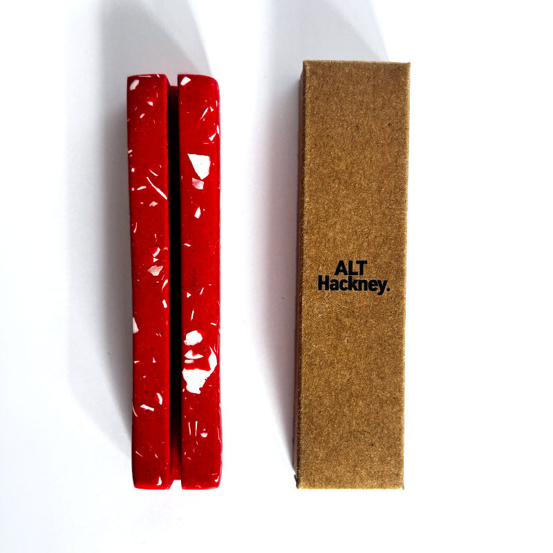 Red rectangular object with white speckles with a brown box labeled 'ALT Hackney' on a white background