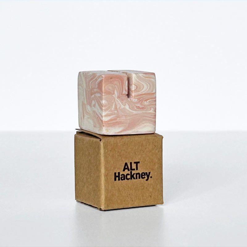 Marble patterned salmon pink small square and white photo holder on a eco brown box with 'ALT Hackney' branding on a white background