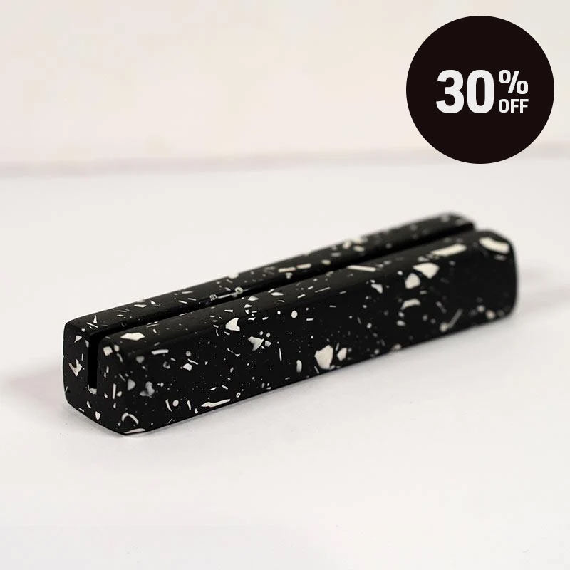 Black and white speckled rectangular object on a light gray background with 30% off black circle promotion badge on top right corner