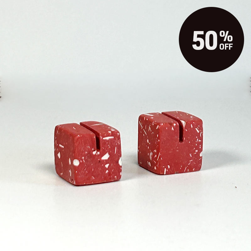 Two small red cube-shaped photo holders on a plain light background. A black circular badge in the top right reads '50% OFF'.