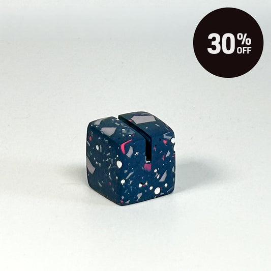 A small cube-shaped product with a dark blue terrazzo pattern featuring white, pink, and gray flecks, shown on a light gray background with a black circular '30% OFF' badge in the top right corner.