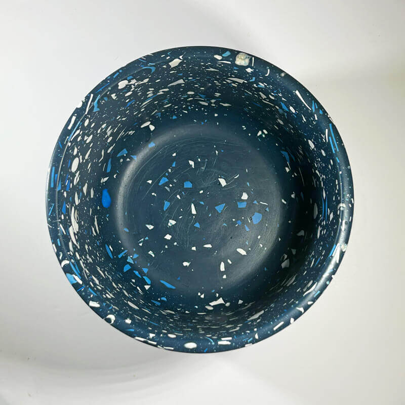 A round dark blue terrazzo plant pot, photographed from directly above on a white background.