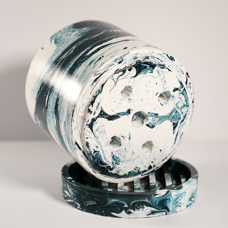 Navy marble-patterned plant pot with drainage holes and a separate tray on a white background