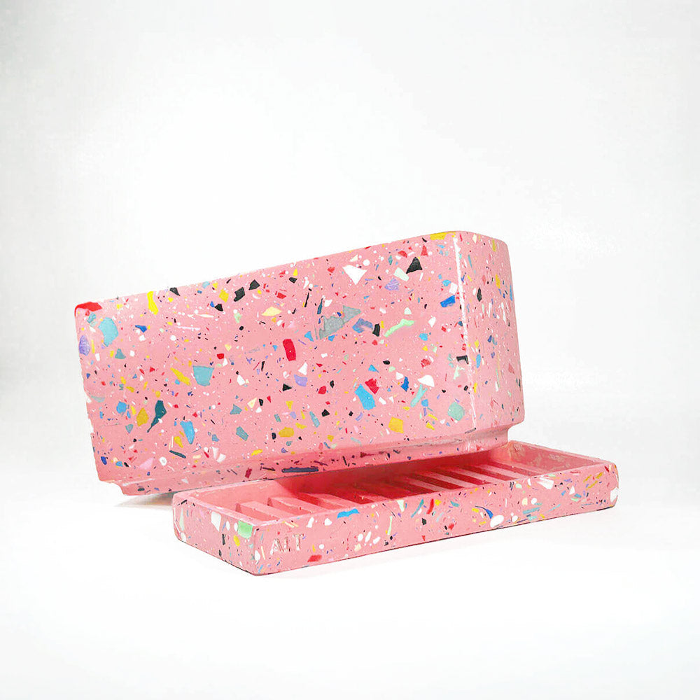Pink rectangular plant pot with colourful speckles terrazzo with drainage holes and a water tray on a white background