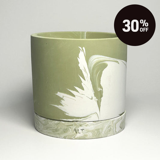 A cylindrical planter pot with a moss green and white marbled design, featuring a matching marble-patterned base and  small drainage holes. A black circular '30% OFF' promotional sticker is in the top right corner.