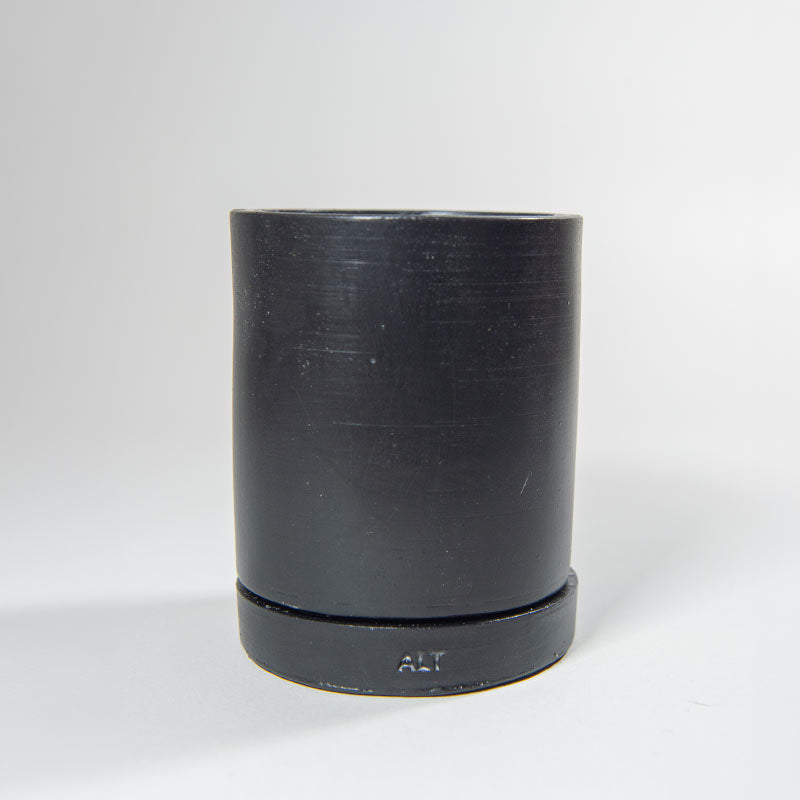 Black Jesmonite plant pot with a separate water tray on a light gray background