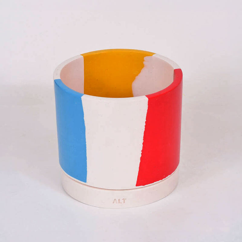Chunky Cylindrical plant pot with blue, yellow and red stripes on a white background