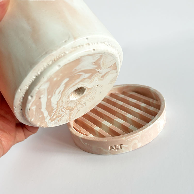 Marbled salmon pink planter with a drainage hole and a water tray with 'ALT' branding on a light gray background