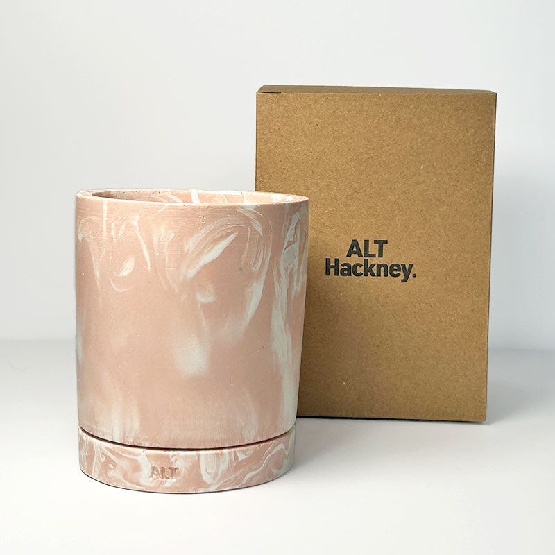 Salmon Pink marbled plant pot with drainage hole and a water tray with 'ALT Hackney' branding next to a branded cardboard box on a white background.