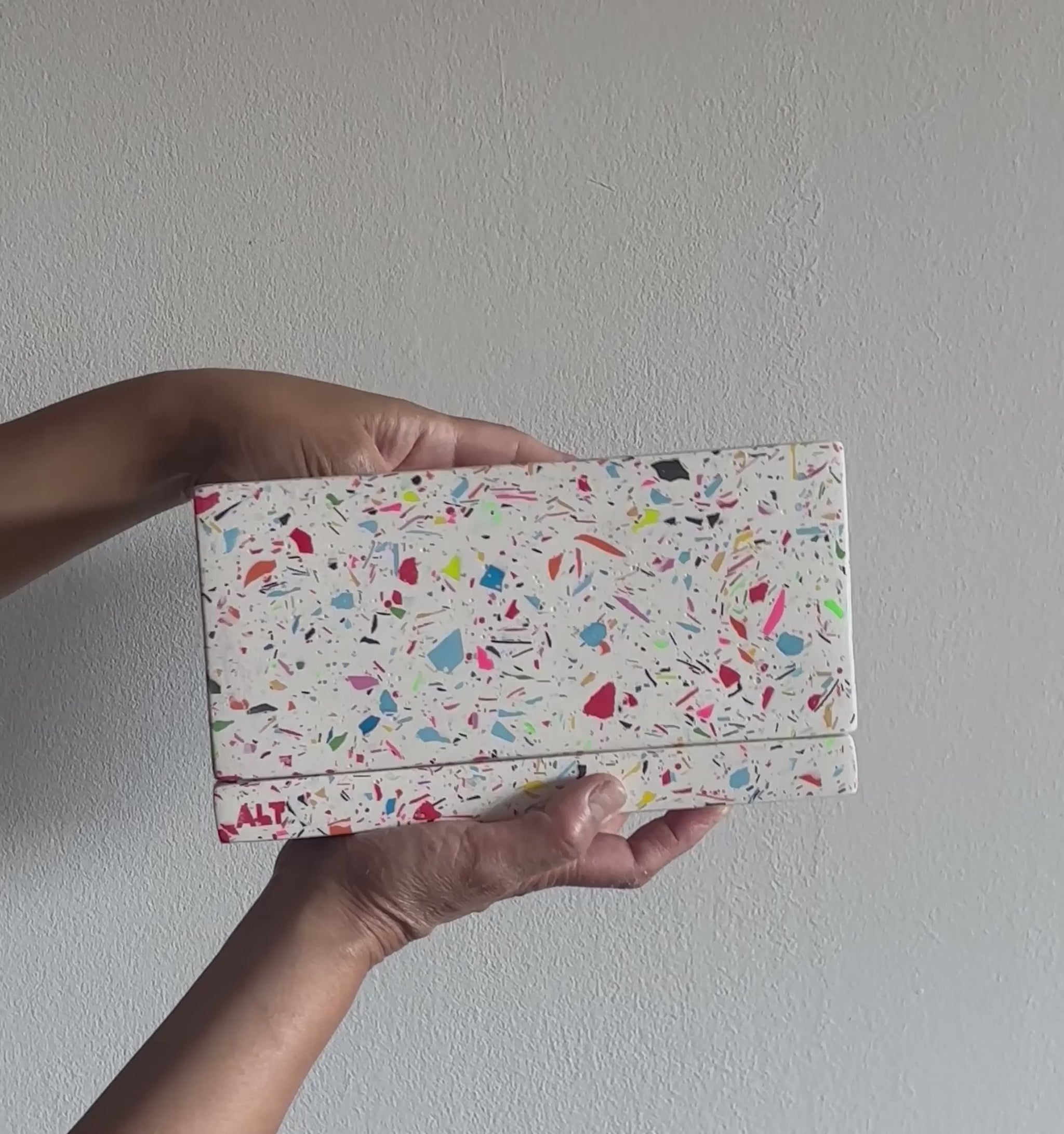 Hands holding a Large Rectangular Rainbow Terrazzo Jesmonite Plant Pot with Drainage holes & Saucer on a white background 