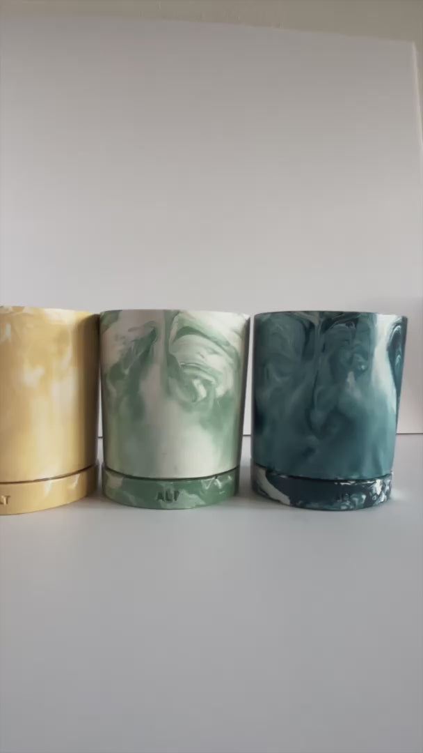 Variety of Marbled planters with a drainage hole and separate water trays with 'ALT' branding on a light gray background