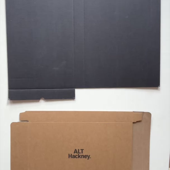Assembling the eco brown packaging box before placing a salmon pink, marble-patterned small rectangular tray inside