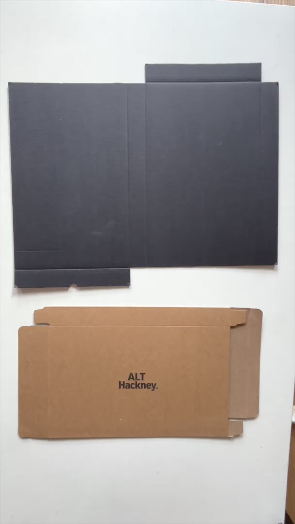 Assembling the eco brown packaging box before placing a salmon pink, marble-patterned small rectangular tray inside