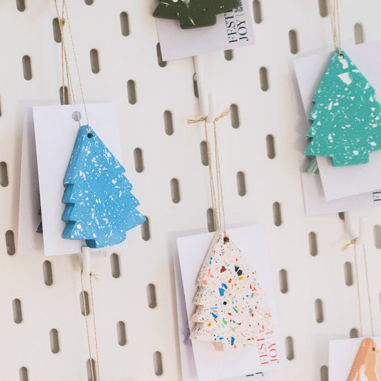Various shaped Christmas decorations on a white peg board
