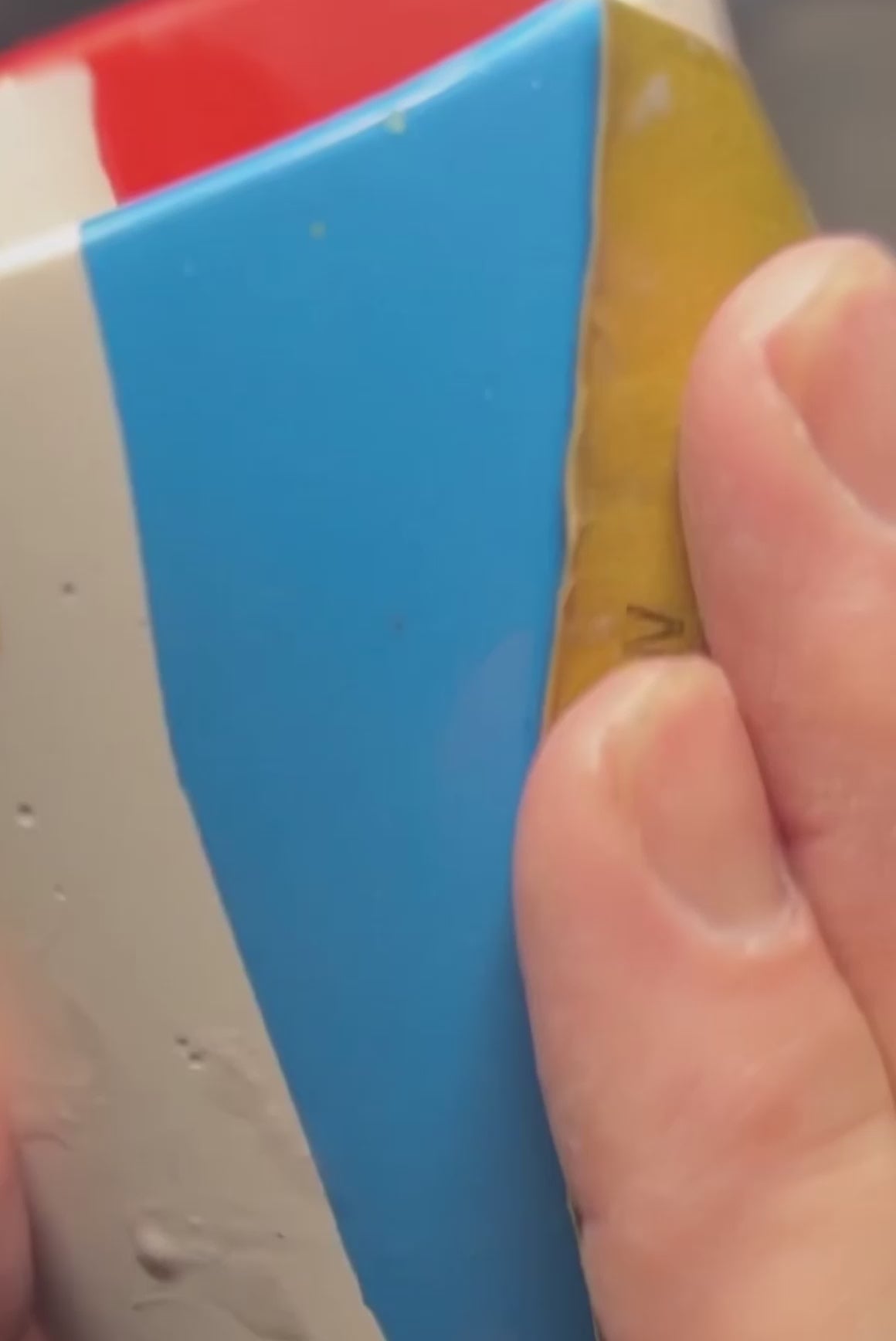 A hand holding a chunky terrazzo pen pot