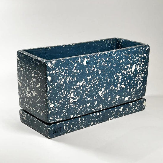 Behind-the-scenes video showing the handmade process of creating a rectangular navy terrazzo Jesmonite plant pot, including casting, finishing, and crafting details in a Hackney studio
