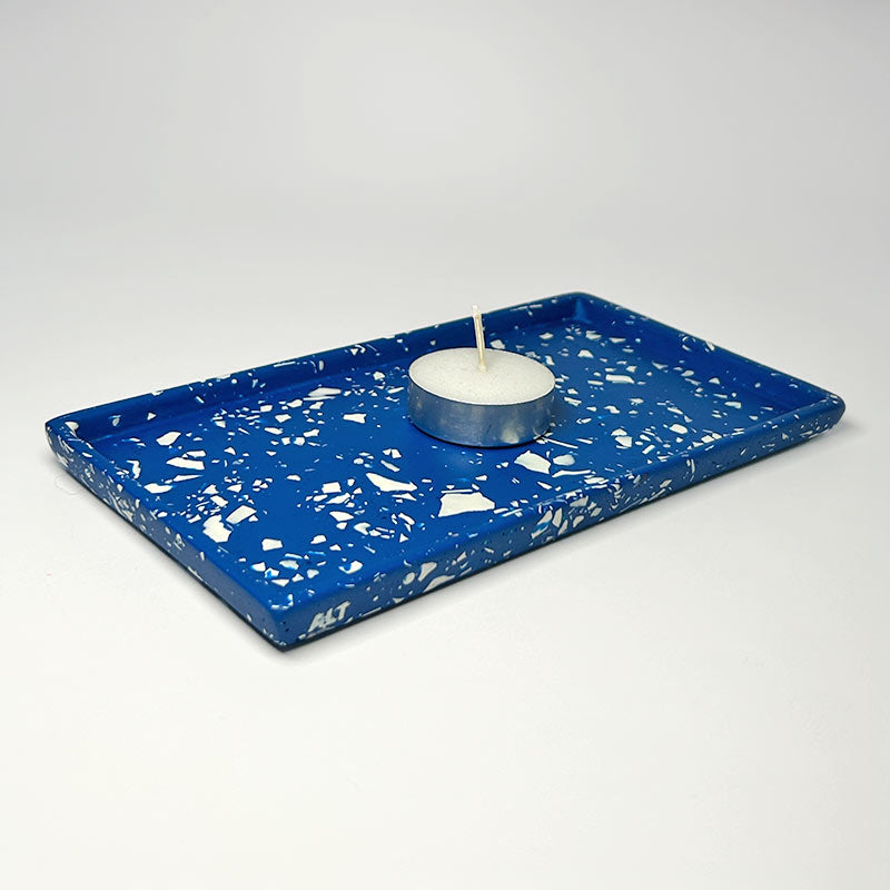 Blue tray with white terrazzo with a candle on a light grey background