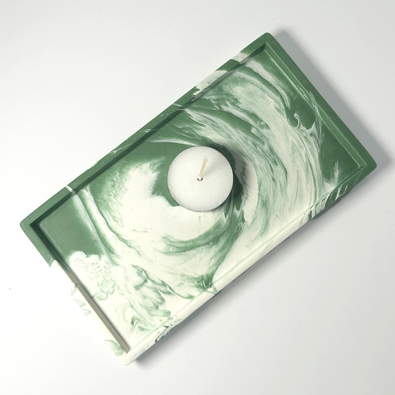 Small Rectangular moss green and white marbled tray with a white tea light candle on a light gray background