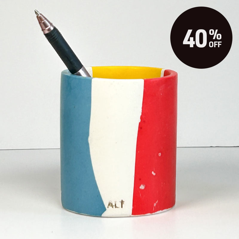 A pen pot with blue, red, and yellow colour block design featuring the text 'ALT' near the bottom. A black circular sticker overlay in the top right corner reads '40% OFF'.