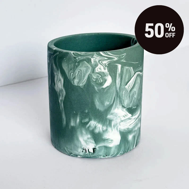 A cylindrical pen pot with a marbled green and white pattern, shown on a light gray background with a black '50% OFF' promotional sticker in the top right corner.