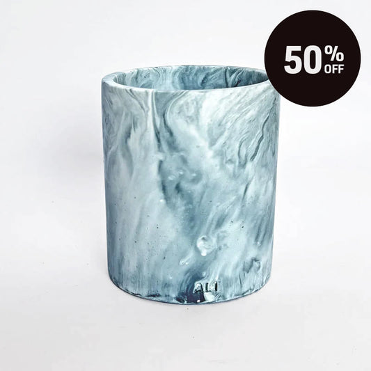 A cylindrical pensil holder with a marble pattern in shades of blue, navy and white, shown on a plain light background with a black '50% OFF' promotional sticker in the top right corner.