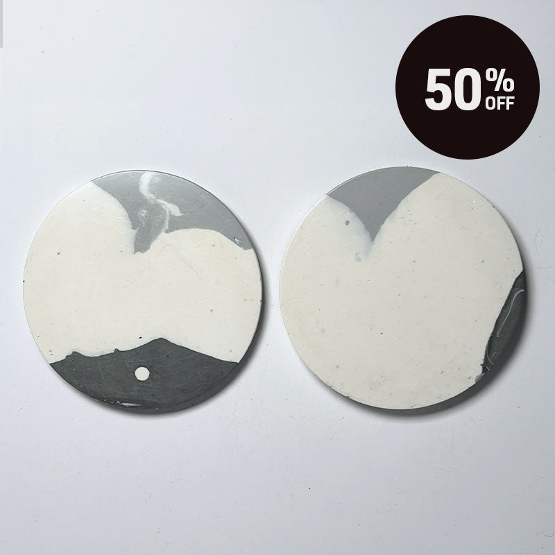 Two round ceramic coasters with a gray and off-white marbled pattern, displayed on a light gray background with a black '50% OFF' promotional badge in the top right corner.