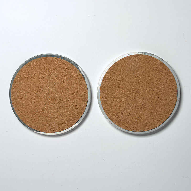 Two round cork coasters  shown side-by-side on a plain white background.