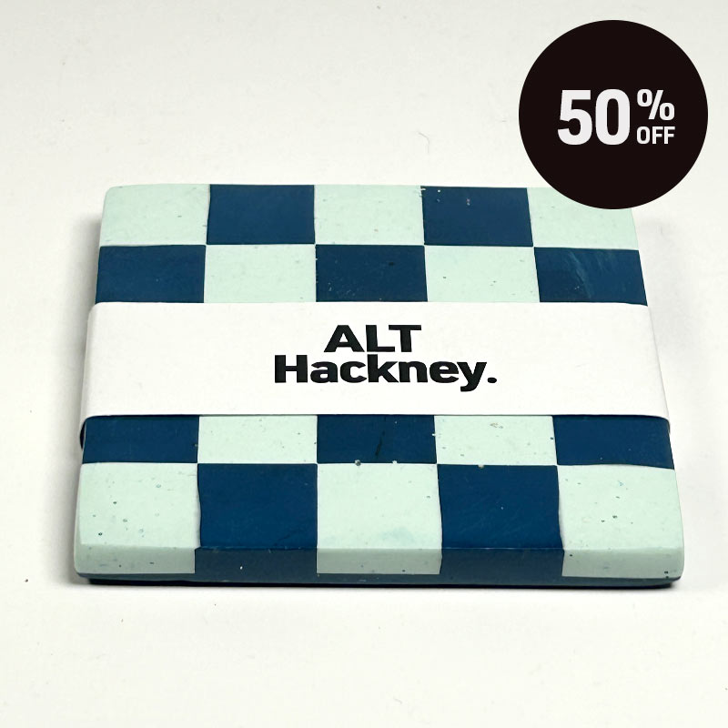 A square coaster with a blue and mint green checkerboard pattern and a white band reading 'ALT Hackney.' in black text and a promotional badge with 50% off on top right corner